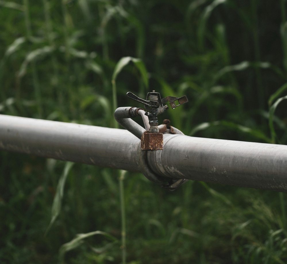 Large industrial irrigation sprinkler with steel pipe in a field